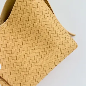 Makroansicht der feinen beigen Webstruktur dieser hochwertigen Damen-Beuteltasche für 2026