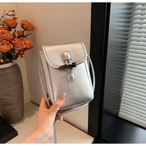 Fashionable silver metallic mini crossbody phone bag featuring a unique toggle button