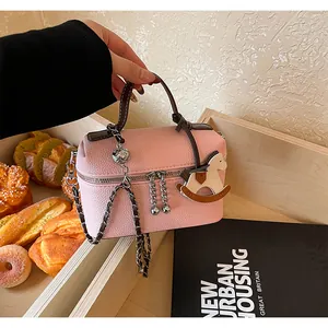 Elegante rosa Lederhandtasche mit Kettengurt und Schaukelpferd-Anhänger-Detail.
