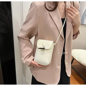 Elegant white mini crossbody phone bag with horn buckle, worn by model for style.