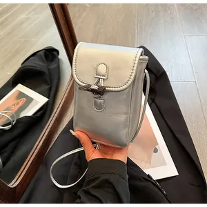 Detailed view of a silver metallic crossbody phone bag with a stylish toggle closure