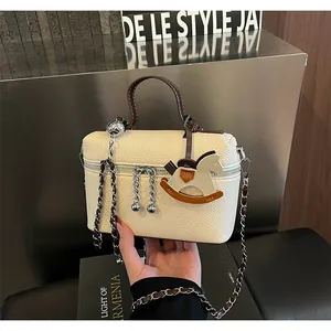Elegante Handtasche aus cremefarbenem Leder mit Schaukelpferd-Charm und Metallkette
