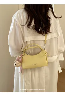 Stylish yellow mini crossbody handbag detailed view with a cute plush bear charm accessory