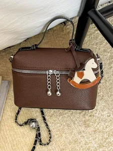Elegante braune Ledertasche mit Schaukelpferd-Anhänger und Kettenriemen für Damen.