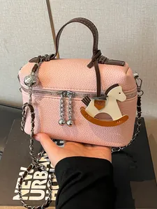 Elegante rosa Handtasche aus Kieselleder mit Schaukelpferd-Anhänger und Silberkettenriemen
