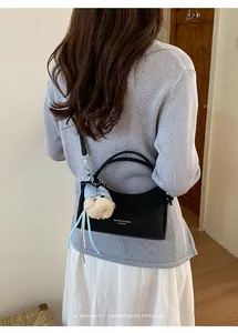 Sophisticated black crossbody handbag with cute charm and minimalist retro vibe