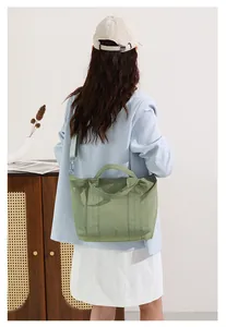Vista posteriore di una donna con un'elegante borsa tote in tela verde per l'uso quotidiano.