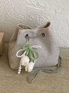 Elegant cream rhinestone bucket bag featuring pearl tulip charm and metal chain strap