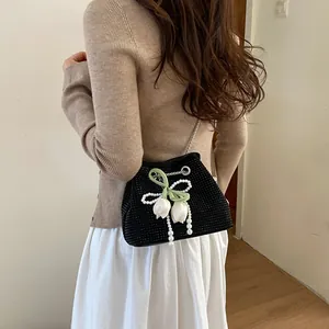 Elegant black rhinestone bucket bag with pearl bow and white tulip charms detail