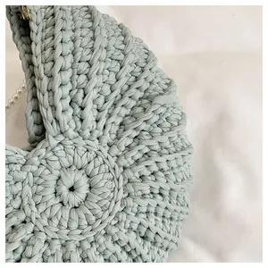 Macro view of detailed knitting texture on a light green shell-shaped woven handbag