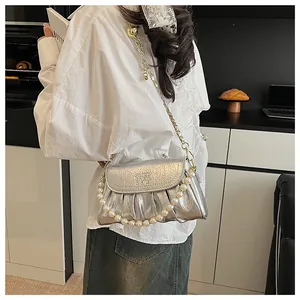 Modella con borsa a tracolla plissettata argento metallizzato e catena di perle