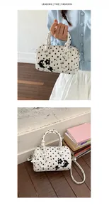 Vues détaillées d'un sac Boston blanc à pois orné de breloques étoile et lune.