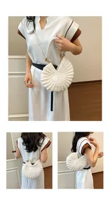 Detailed view of a stylish white woven conch shell bag featuring a pearl strap for women