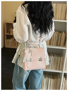 Vista posteriore di un elegante zaino rosa da donna con fiocco di pizzo e stelle