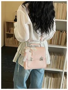 Dettaglio di uno zaino rosa da donna con stelle e fiocco di pizzo bianco indossato