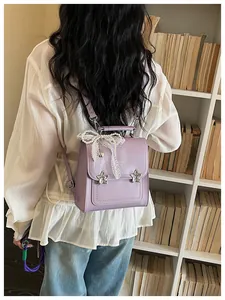 Dettaglio ravvicinato di uno zaino viola alla moda con stelle e un fiocco in pizzo bianco