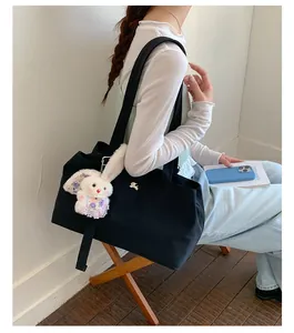 Lifestyle view of a large black nylon tote bag worn by a model in a casual setting