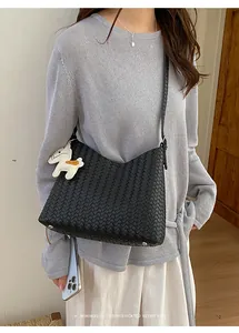 Minimalistische schwarze geflochtene Hobo-Schultertasche mit weißem Pferdeanhänger