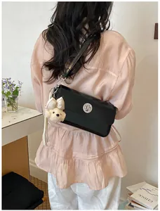 Stylish back view of woman wearing a black vintage square bag with a cute bear charm