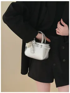 Elegant silver metallic bucket handbag for women featuring a pearl lace bow charm
