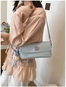 Elegant light blue vintage shoulder bag with silver circular lock and plush bear charm