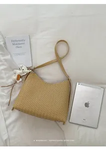 Detailansicht der khakifarbenen gewebten Hobo-Tasche mit Accessoire und Tablet-Größe