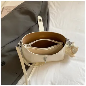 Gedetailleerd bovenaanzicht van een crèmekleurige bucket bag met uitneembare binnentas