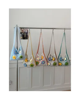 Five colorful crochet shoulder bags with floral designs hanging on a minimalist rack.