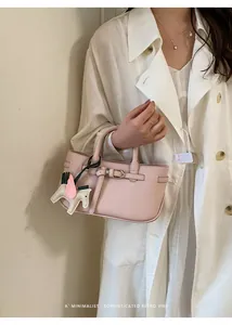 Primo piano di un'elegante borsa tote rosa con un ciondolo a forma di cavallo alato