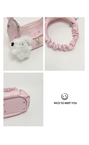 Dettaglio borsa rosa con motivo a stelle, ciondolo in peluche e manico arricciato.