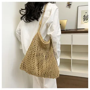 Detalle de un bolso de hombro beige tejido a mano con diseño calado para el verano