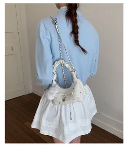 Vista posteriore di una borsa a tracolla bianca con stelle colorate e ciondolo a coniglio