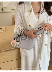 Primo piano di una borsa tote in pelle lilla con un ciondolo a cavallo.