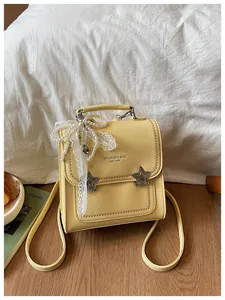 Dettaglio ravvicinato di uno zaino crema con fiocco decorativo in pizzo e stelle.