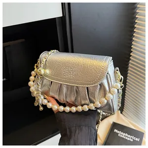 Borsa a mano a pieghe argento metallizzato con elegante catena in perle e oro.