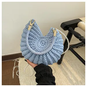 Light blue conch shell-shaped woven handbag with a sophisticated pearl chain strap