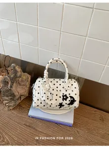 Sac Boston matelassé à pois blancs avec breloques étoile et lune sur fond lifestyle