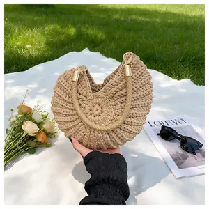 Detail view of the conch-shaped woven texture on the beige summer straw handbag