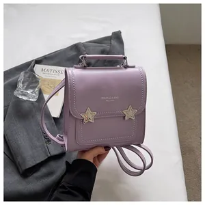 Elegante zaino in ecopelle viola con motivi a stella mostrato su una giacca grigia