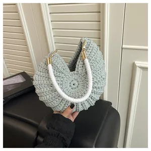 Close-up detail of mint green hand-woven conch shell bag with white braided handle