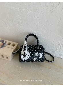 Détail d'un sac Boston matelassé noir à pois blancs avec motifs d'étoiles et de lunes