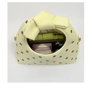 Vista interna della mini borsa gialla a pois con spazio per telefono e ombrello.