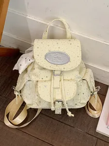 Sweet light yellow canvas backpack with silver star patterns and a cute star charm