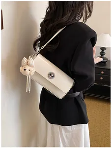 Close-up of a vintage cream-white rectangular shoulder bag worn by a model