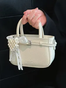 Elegant cream mini handbag with pearl heart charm and lace detail for women's daily commute.