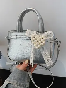 Metallic silver handbag featuring crumpled texture and elegant pearl heart bow accessory