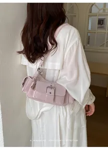 Back view of a trendy pink underarm bag with metal buckle on a white outfit.