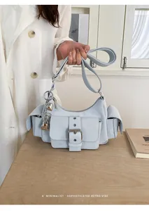 Light blue underarm bag featuring buckle detail and heart charms with a retro vibe