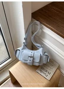 Detailed view of the light blue multi-pocket underarm bag with a retro buckle design