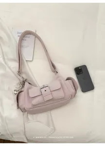 High-quality detail of a pink minimalist underarm bag with silver buckle and side pockets.